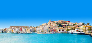 Uitzicht op het strand met hotels en bergen op de achtergrond op Ibiza