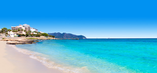 Uitzicht op het strand met hotels en bergen op de achtergrond op Mallorca