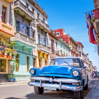 Retro auto en gekleurde huizen in West-Cuba