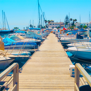 Gekleurde-bootjes-liggend-aan-een-houten-pier-in-de-haven-van-Sousse