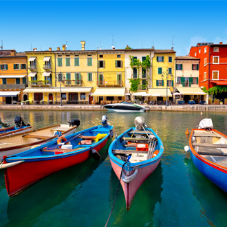 De haven van Peschiera del Garda met gekleurde bootjes en huisjes, Italië