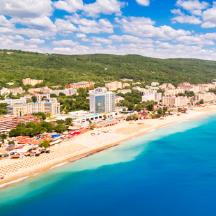 Uitzicht op het zandstrand, helderblauwe zee en gebouwen aan de Zwarte Zeekust, Bulgarije