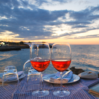 Reflecterende-zonsondergang-in-wijnglazen-tijdens-een-romantisch-diner-op-het-strand-van-Gouves