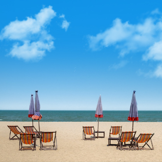 Het strand van Cha Am met strandstoelen, parasols en uitzicht op de zee in Midden Thailand