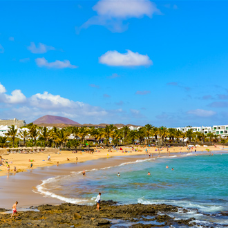 Strand-met-toeristen-en-palmbomen-in-Costa-Teguise-Lanzarote