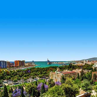 Uitzicht over groene bomen en de zee in Malaga