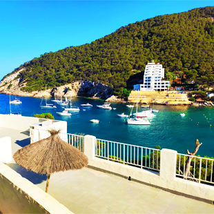 Uitzicht-op-zee-vanaf-een-balkon-op-het-strand-Cala-Llonga-Ibiza