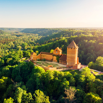 Een kasteel omgeven door bossen in Letland