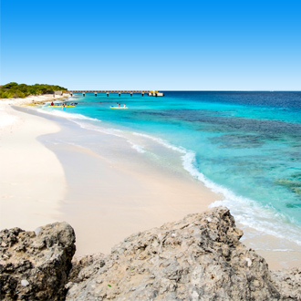 Wit zandstrand met helderblauw zeewater op het eiland Bonaire