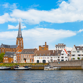 De maas is Maastricht met uitzicht op gebouwen en bootjes in Nederland