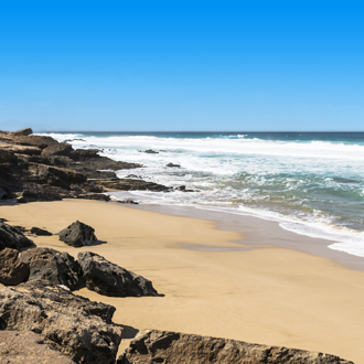Kustlijn met aan een klein strandje met rotsen op Fuertaventura.