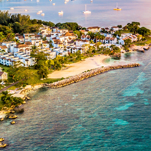 De kustlijn van Negril met huizen en bootjes, westkant Jamaica