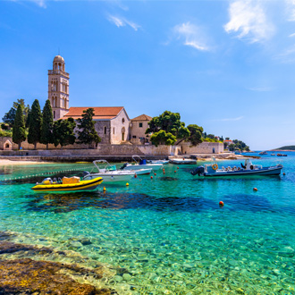 Prachtige foto van een kerkje met een haventje op de voorgrond in Hvar, Kroatië