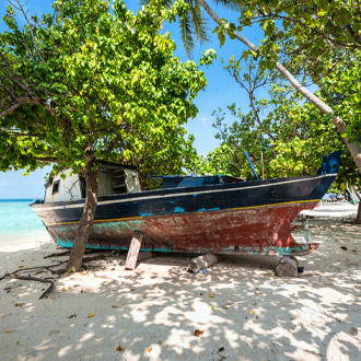 Oud bootje op het strand van Gulhi eiland Zuid Male Atol