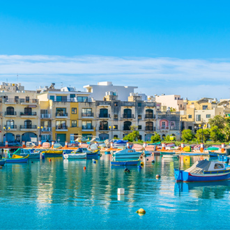 Foto van huizen en water met bootjes in Birzebugga Malta