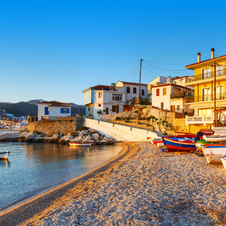 Uitzicht op huisjes, het strand en vissersboten in Kokkari op Samos