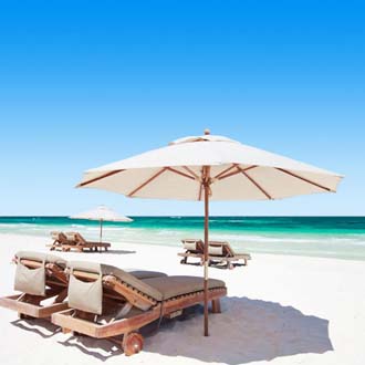 Ligbedjes en een parasol op het witte zandstrand bij Playa del Carmen in Mexico