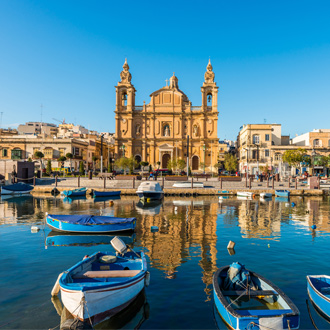 Vissersbootjes in de haven van Sliema met de kerk op de achtergrond