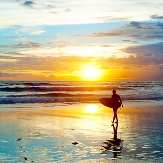 Surfer bij zonsondergang in Kuta