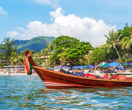 <p>Vrolijk gekleurde boot op Kata Beach, Thailand</p>