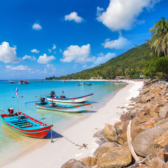 <p>Wit strand met gekleurde bootjes Koh Phangan</p>