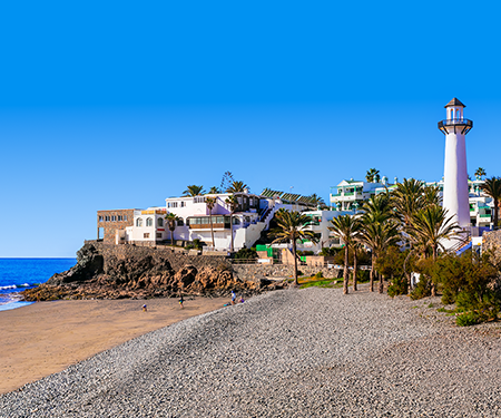 <p>De mooie witte vuurtoren aan het strand van Bahia Feliz</p>