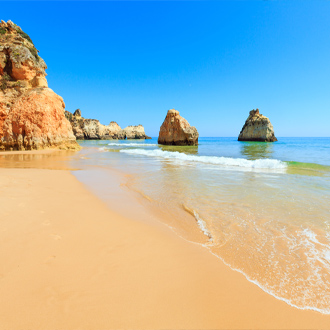 Het strand van Alvor met rotsblokken in de Algarve, Portugal