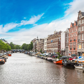 Het kanaal met bootjes en huizen in Amsterdam
