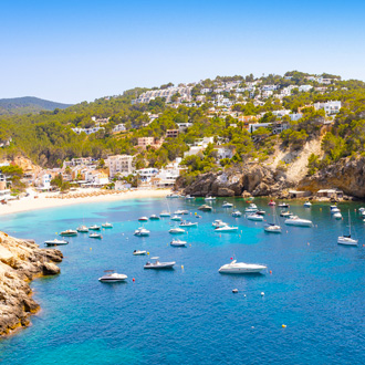 Boten op het blauwe water in Cala Vadella Ibiza