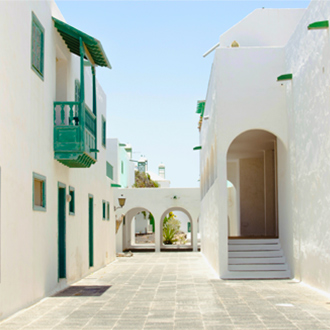 Typische-straat-met-witte-huizen-en-groene-deuren-en-ramen-in-Costa-Teguise-Lanzarote