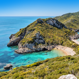 Het strand en helderblauwe zee in Agios Georgios op het Griekse eiland Corfu