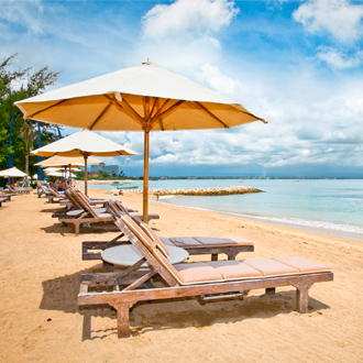 Ligbedjes met parasols op het strand van Sanur op Bali Indonesie