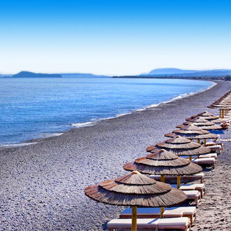 Strandbedjes en parasols op het strand van Kolymbari