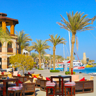 De haven van Port Ghalib met palmbomen en een terras in Egypte