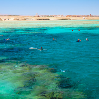 Een koraalrif waar mensen in snorken in Port Ghalib, Egypte