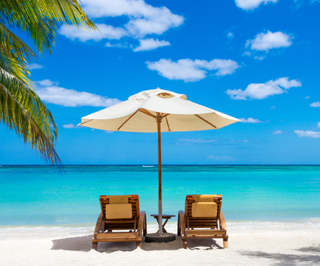 <p>Strandstoelen met parasol op een tropisch wit strand</p>