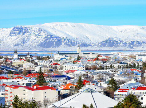 <p>Overzicht van Reykjavik met besneeuwde bergen</p>