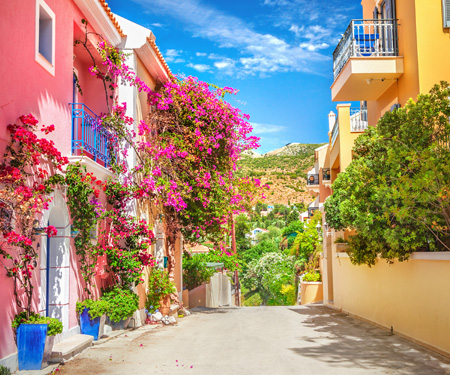 <p>Straatje met gekleurde gevels op het Ionische eiland Kefalonia</p>