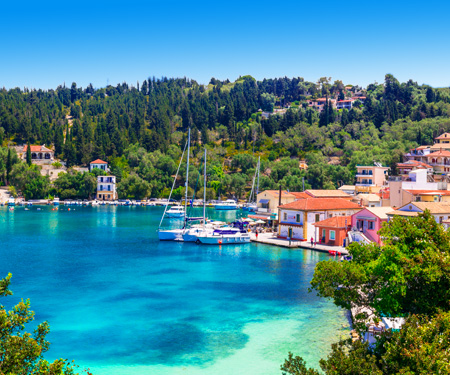 <p>Bootje in de blauwe zee met groene heuvels op de achtergrond op het Ionische eiland Paxos</p>