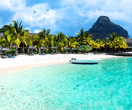 <p>Wit strand met palmbomen aan een blauwe zee op Mauritius</p>