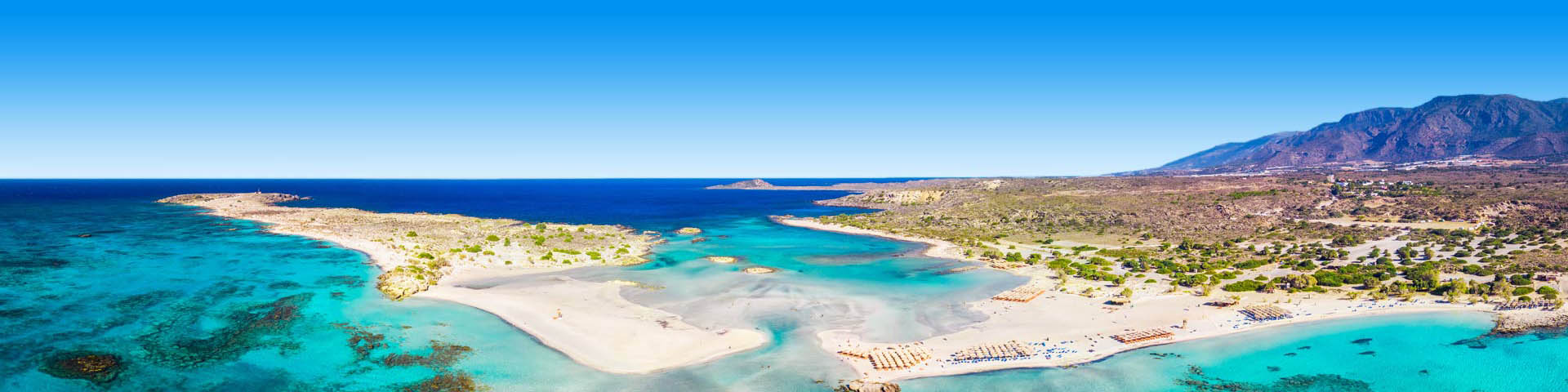 Uitzicht over helderblauwe baaitjes eindigend in de zee bij Kreta