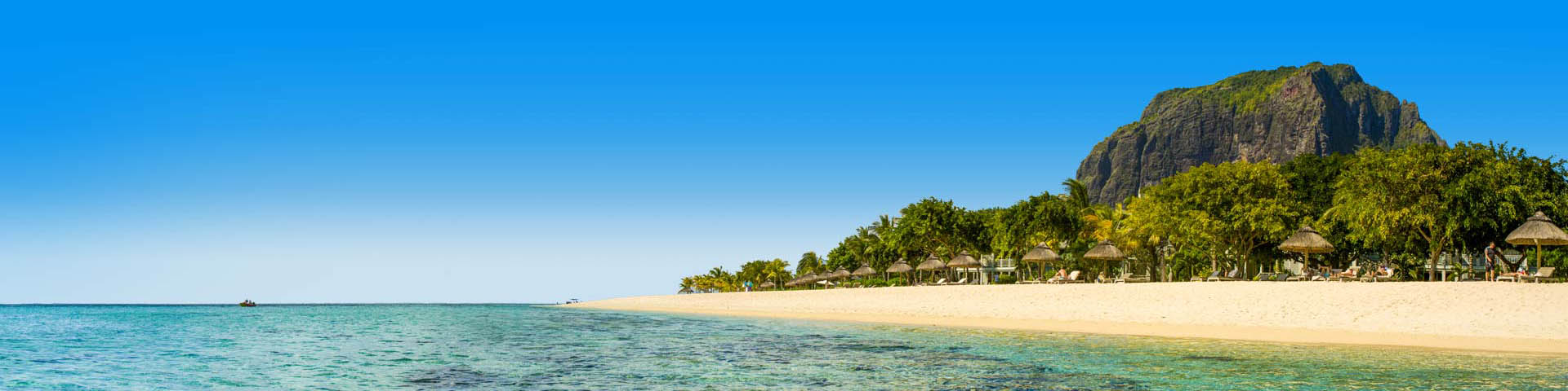 Zee met zandstrand en palmboom parasols op Mauritius