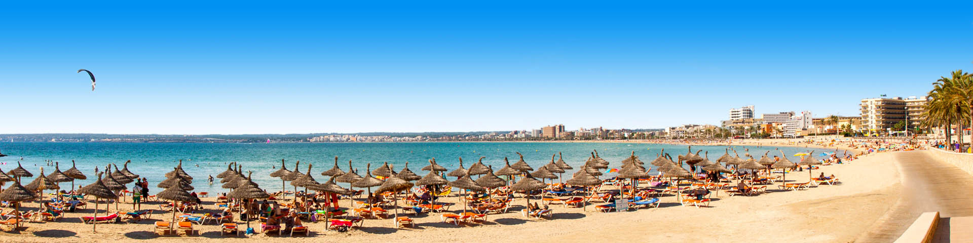 Ligbedjes met parasols op het strand van Playa de Palma op Mallorca