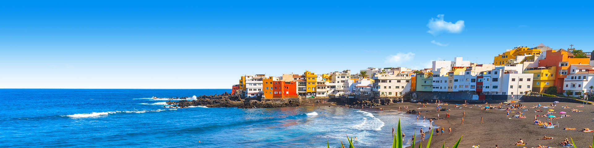 De zee en gekleurde huisjes in Puerto de la Cruz 