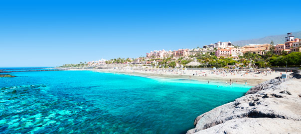 Blauwe zee met mooi strand en stad op de Canarische Eilanden