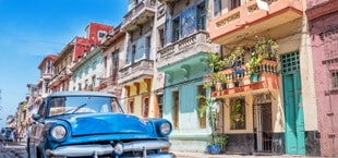 Klassieke oude auto met gekleurde huizen op Cuba