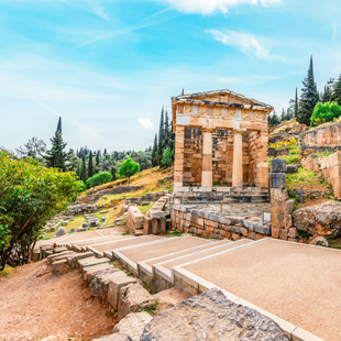 Griekse ruïnes in Delphi met een goed bewaard tempelgebouw en stenen zuilen, gelegen op een heuvel met uitzicht op groene valleien.