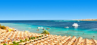Wit strand met parasols en blauwe zee in Egypte