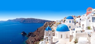 Blauwe zee met Griekse witte huisjes in Griekenland