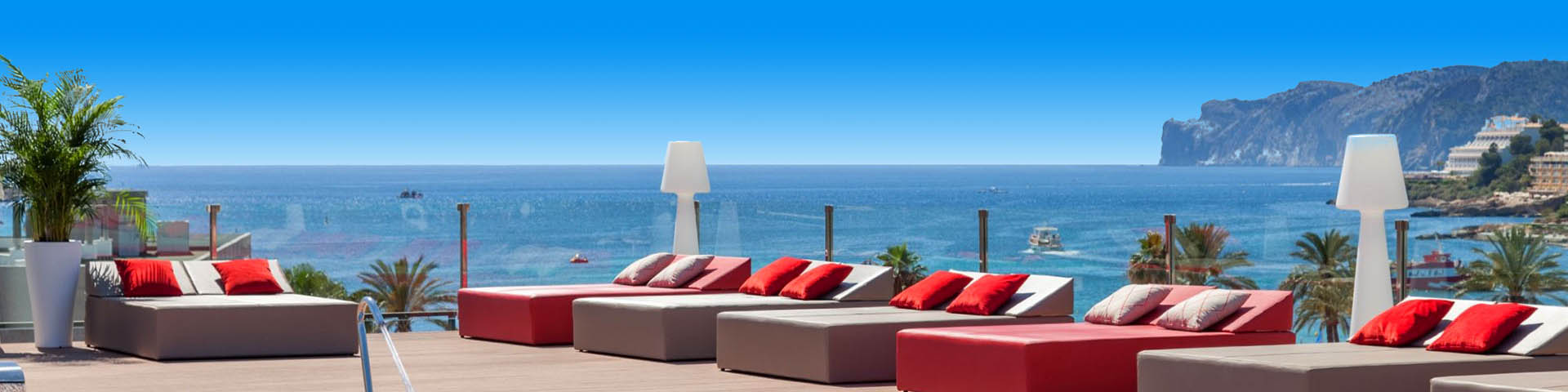 Ligbedden met kussens met uitzicht op de zee bij een Zafiro hotel
